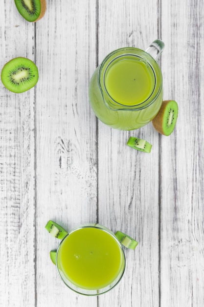 Table en bois vintage avec des smoothies Kiwi fraîchement préparés