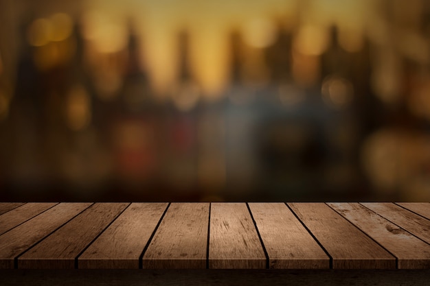 Table en bois avec vue sur le fond de la barre de boissons floue