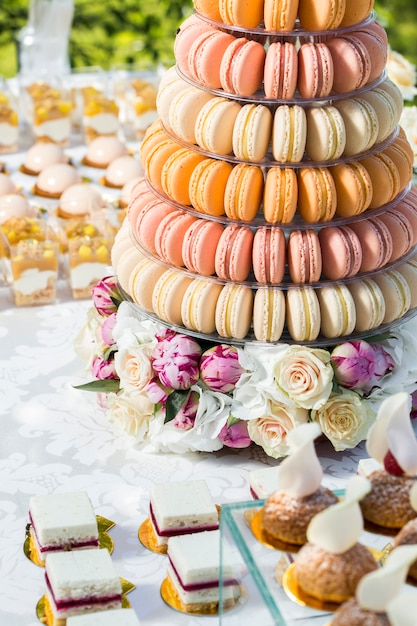 Table avec des bonbons décorés de fleurs et gâteau macaron