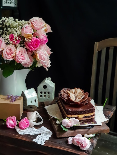 Une table avec un bouquet de fleurs et un gâteau dessus