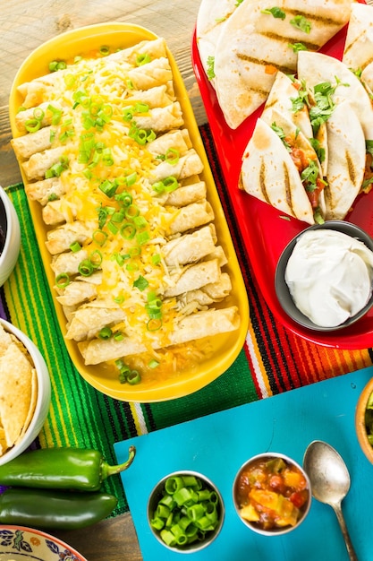 Table de buffet de fête Fiesta avec taquitos au poulet et autres plats mexicains traditionnels.