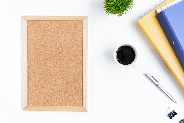 Table de bureau blanc et équipement pour travailler avec du café noir et un tableau blanc dans la vue de dessus et le concept de ray plat.