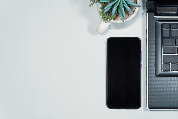 Table de bureau blanche moderne avec ordinateur portable et smartphone