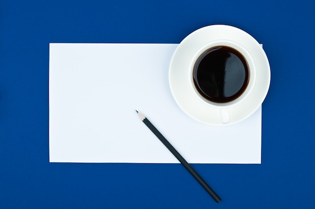 Table de bureau avec bloc-notes, crayon et tasse de café. Vue de dessus avec espace copie