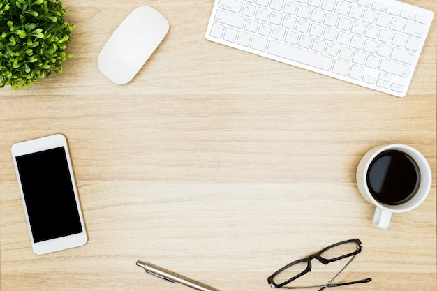 Table de bureau en bois avec des gadgets informatiques et des fournitures