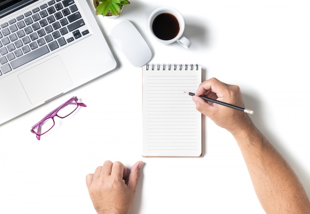 Table de bureau de bureau blanc avec main homme écrit sur un cahier vierge