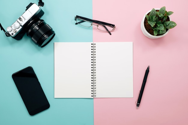 Table de bureau avec cahier, clavier, stylo, tasse de café et fleur. Vue de dessus avec espace copie.