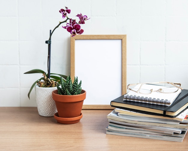 Table de bureau avec cahiers, fournitures et plantes d'intérieur