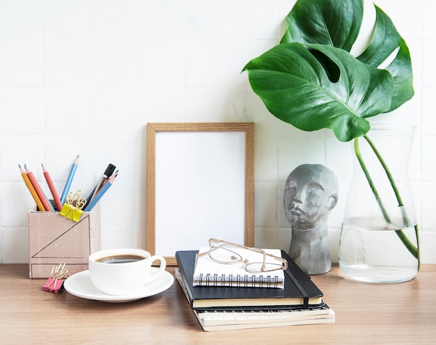 Table de bureau avec cahiers, fournitures et tasse à café.