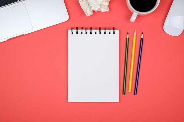 Table de bureau de concepteur moderne avec page de cahier vierge, ordinateur portable et tasse de café