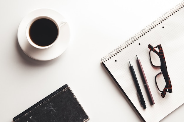 Table de bureau avec fournitures, tasse à café et fleur. Vue de dessus avec espace de copie