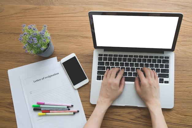 Table de bureau avec la main de l&#39;homme en tapant sur ordinateur portable