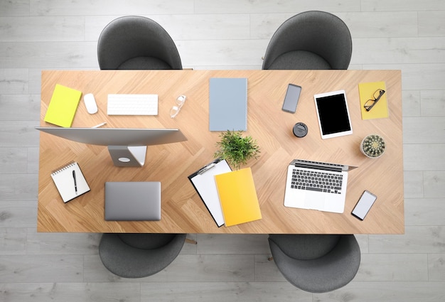 Table de bureau moderne avec appareils et chaises vue de dessus