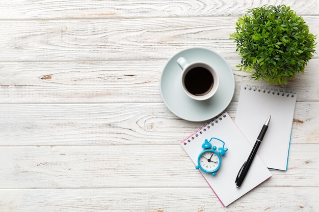 Table de bureau moderne avec bloc-notes et autres fournitures avec une tasse de café Page de bloc-notes vierge pour votre conception Vue de dessus mise à plat