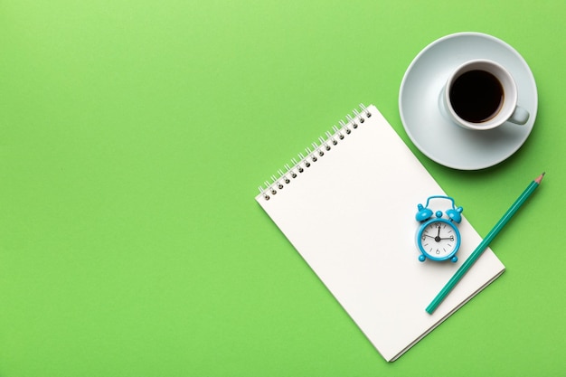 Table de bureau moderne avec bloc-notes et autres fournitures avec une tasse de café Page de bloc-notes vierge pour votre conception Vue de dessus mise à plat