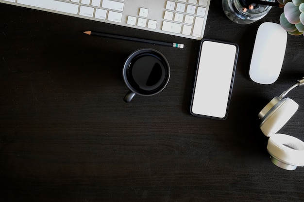 Table de bureau avec ordinateur, téléphone portable, fournitures et tasse à café.