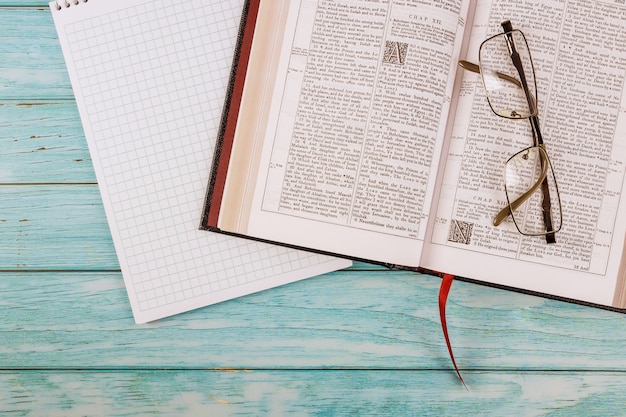 Table de bureau a ouvert la Sainte Bible fermer le temps de prière sur le bloc-notes