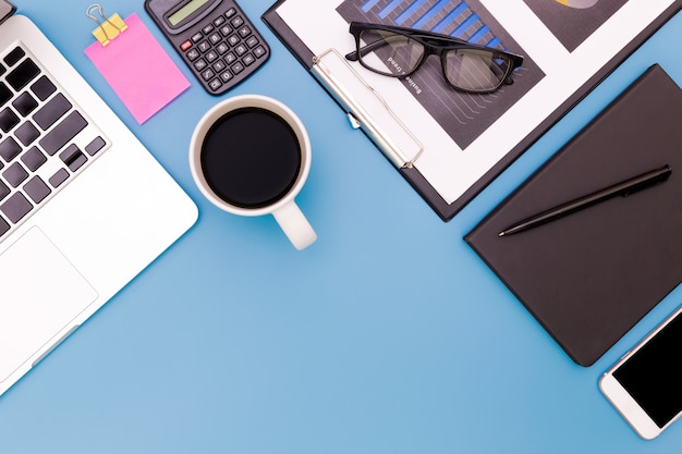 table de bureau plat laïque du lieu de travail moderne avec ordinateur portable sur la table bleue