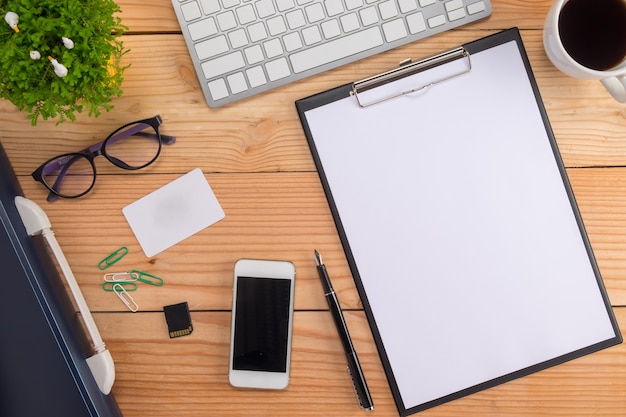 Table de bureau avec stylo, clavier sur ordinateur portable, tasse de café et fleur. Vue de dessus avec copie (focus sélectif).