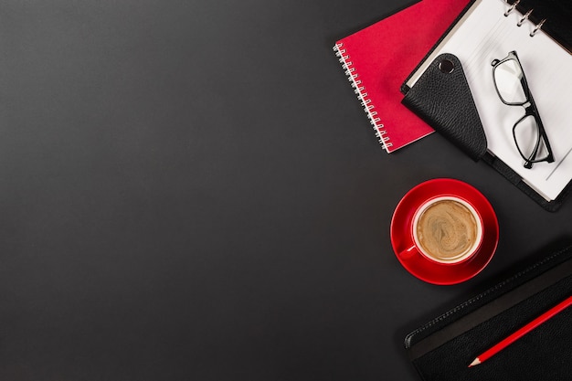 Table de bureau avec une tasse de café et des cahiers. Vue de dessus avec espace de copie