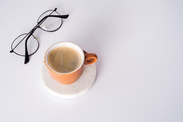 Table de bureau avec tasse à café, stylo et verres. Vue de dessus avec espace copie