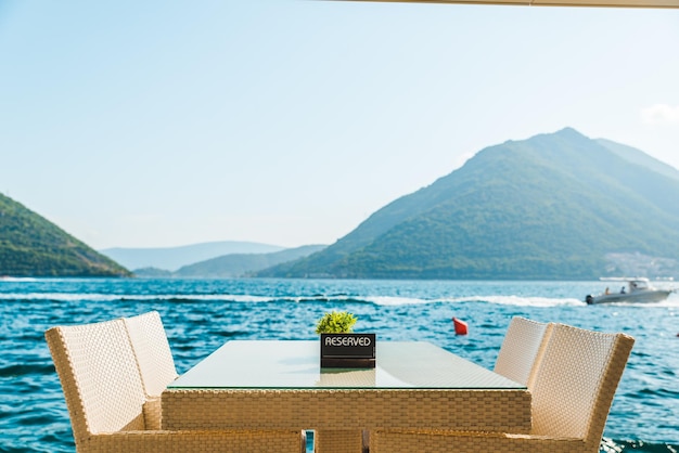 Table de café sur la plage avec vue magnifique sur la mer et les montagnes assiette réservée dessus