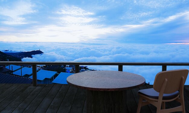 Table et chaise en bois Sur la terrasse en bois du restaurant au sommet de la montagne, il y a une mer de brume en arrière-plan.