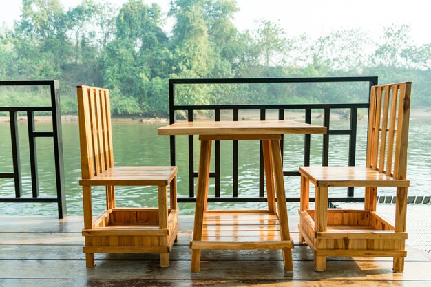 Table et chaise en bois sur la terrasse près de la rivière