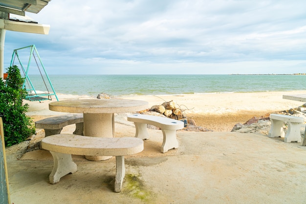 table et chaise extérieure de patio vide sur la plage avec le fond de plage de mer