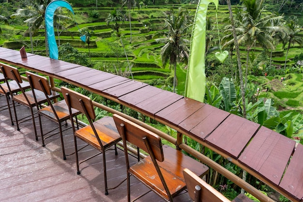 Table et chaises en bois dans un café tropical vide à côté de rizières en terrasses de l'île de Bali Indonésie