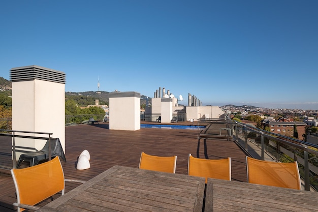 Table et chaises en bois vides sur le toit avec vue sur la ville