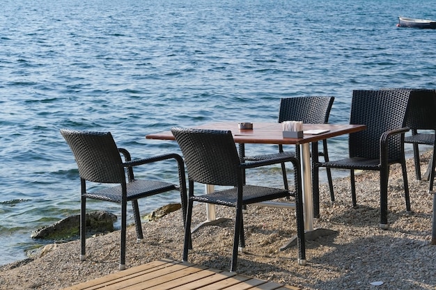 Table et chaises sur le café de la plage sur fond d'eau