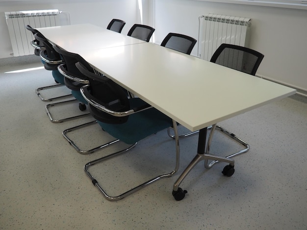 Table et chaises dans la salle de réunion ou dans l'auditorium Bureau de la bibliothèque ou locaux d'une institution officielle ou d'une banque Il n'y a personne à la table Peintures blanches, noires et grises à l'intérieur