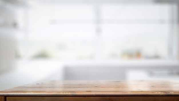 Table de comptoir en bois vide dans le fond de la salle de cuisine blanche.