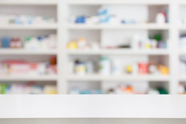 Table de comptoir de pharmacie avec fond abstrait flou avec médicaments et produits de santé sur les étagères