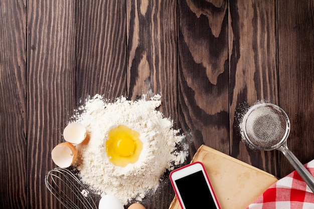 Table de cuisine avec ingrédients ustensiles et livre de cuisine