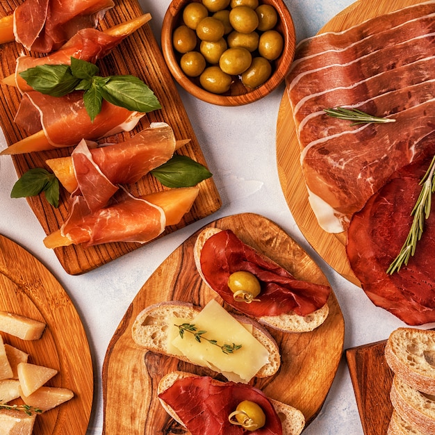 Table de cuisine italienne avec jambon, fromage, olives.