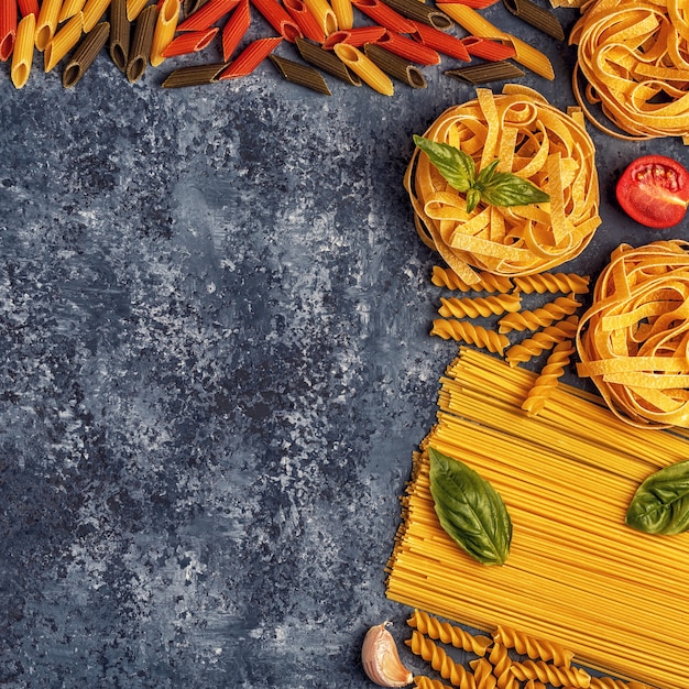 Table de cuisine italienne avec des pâtes, des épices et des légumes.