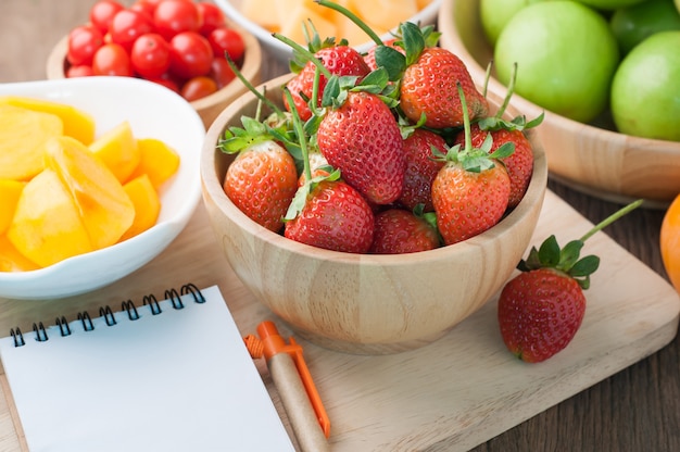 table de cuisine avec des variétés de fruits et écran blanc sur du papier de cahier.