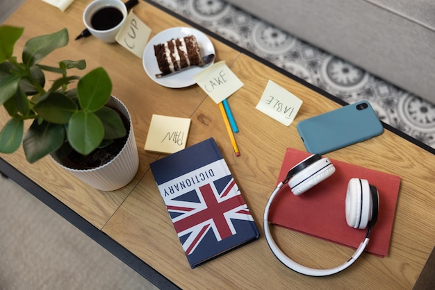 Une table dans une chambre d'adolescents pleine de choses comme des écouteurs de téléphone, des livres, des stylos et de la nourriture