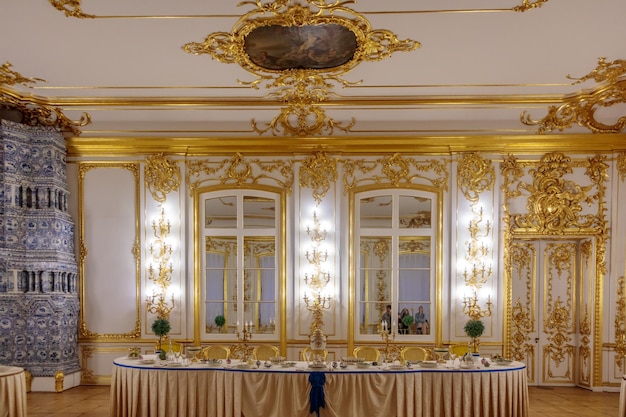 Une table dans une pièce avec des meubles dorés et blancs et un miroir.