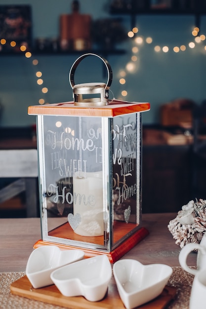 Table décorée avec bougie et vaisselle pour la fête avec des lumières sur le fond. Concept de réveillon du nouvel an