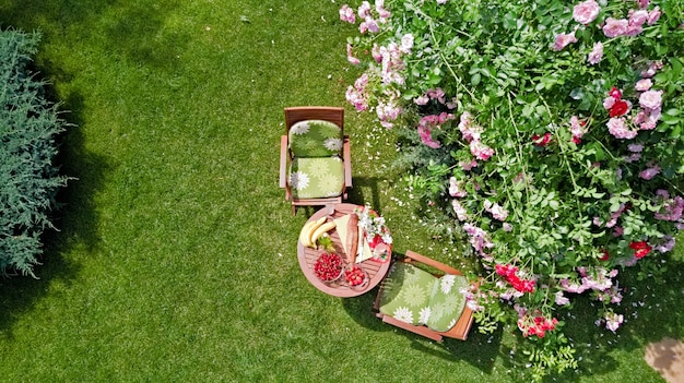 Table décorée avec du pain aux fraises et des fruits dans la belle vue aérienne de la roseraie d'été