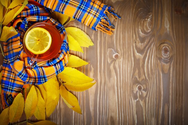 La table, décorée de feuilles d'automne et de thé frais