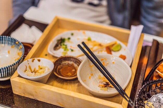 Table désordonnée après le repas dans un restaurant japonais Concepts de restes de repas à finition sale