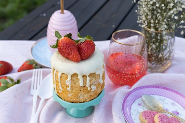 Table avec dessert aux fraises et boisson rouge