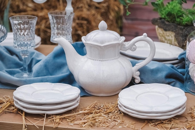 Table à dessert de banquet décorée d'assiettes couverts verres théière en céramique