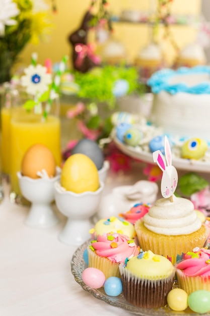 Table à desserts avec gâteau et cupcakes pour le brunch de Pâques.