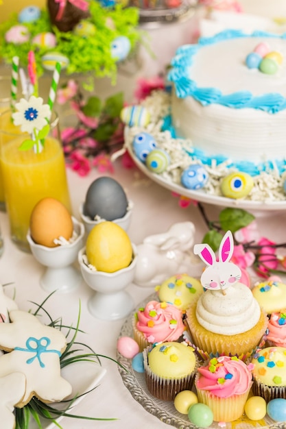 Table à desserts avec gâteau et cupcakes pour le brunch de Pâques.