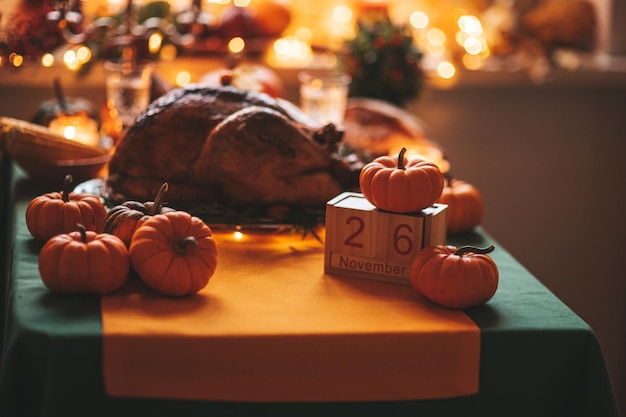 Table de dîner de vacances de Thanksgiving avec citrouilles et calendrier en bois dans la décoration d'automne